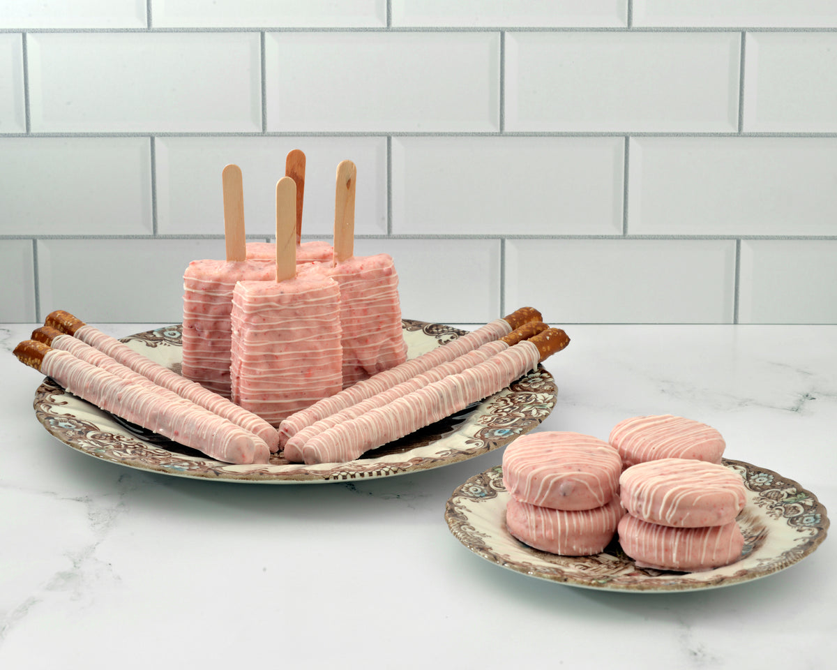 Pink dipped pretzel rods, Rice Krispie treats and Oreos